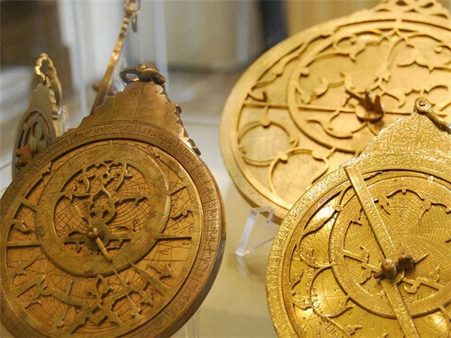 коллекция старинных астролябий в музейной витрине