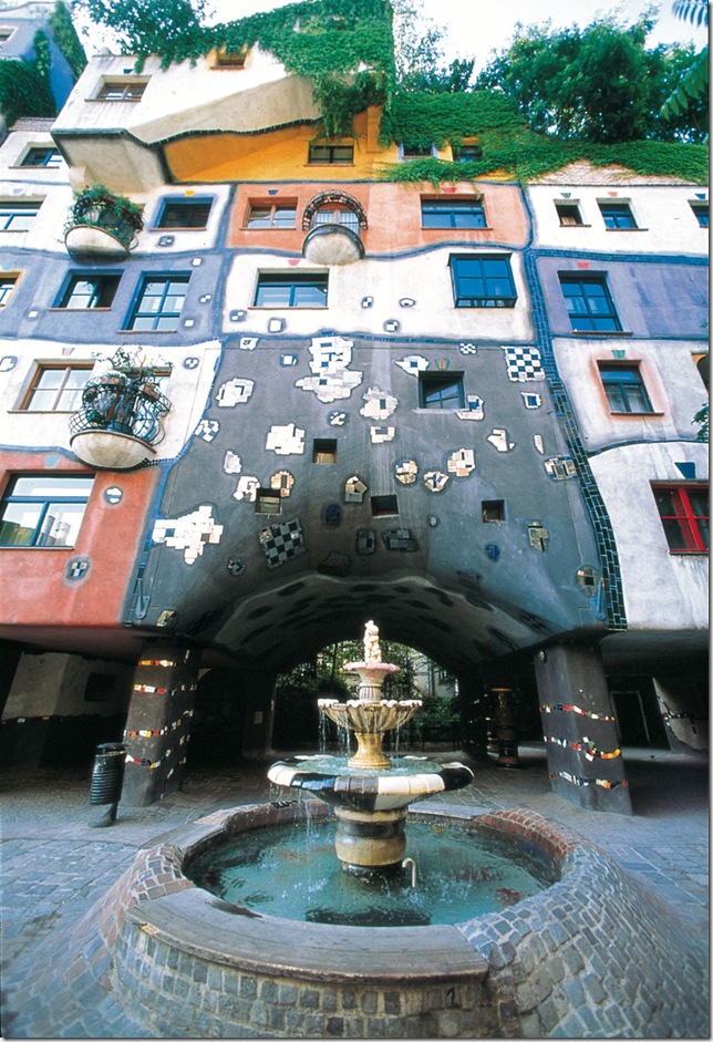 жилой дом Hundertwasserhaus с зелёной крышей и разноцветными фасадами